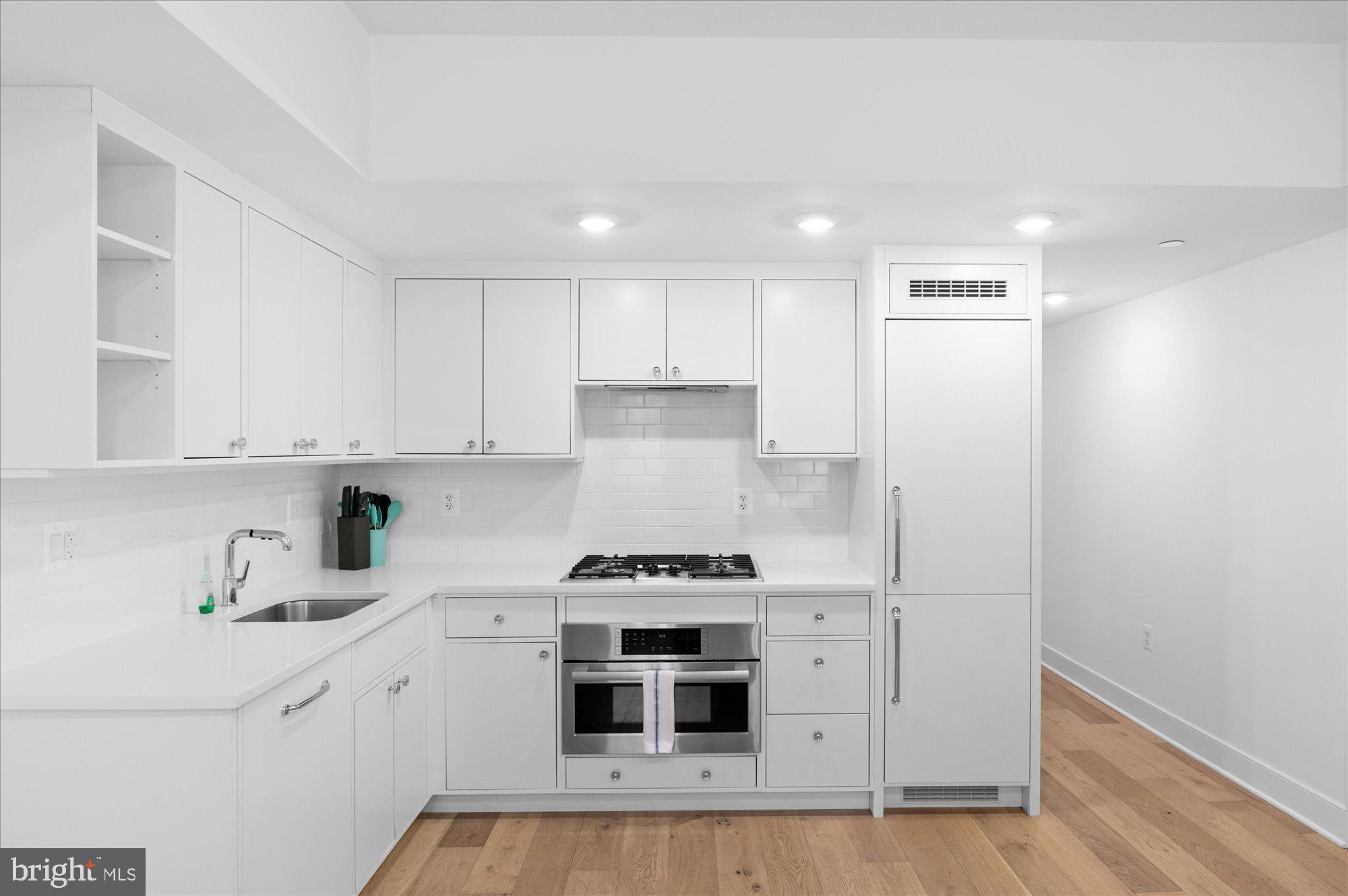2869 28th Street Northwest, Unit 301 Washington, DC 20008 - Photo 14 of 31 a kitchen with a stove and white cabinets