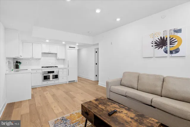 a living room with furniture and kitchen view