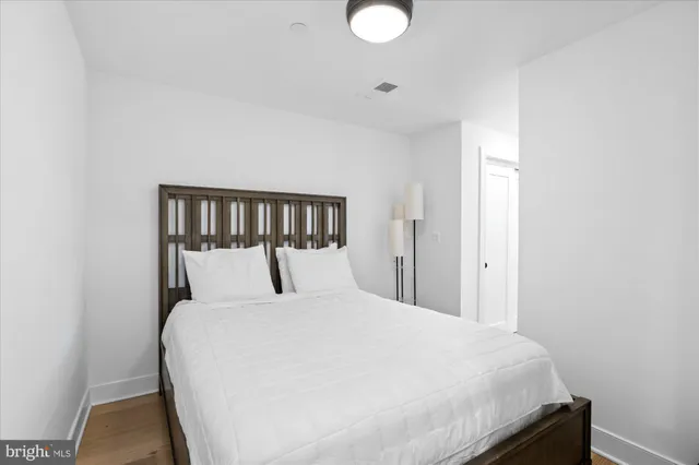 a large bed sitting in a bedroom next to a window