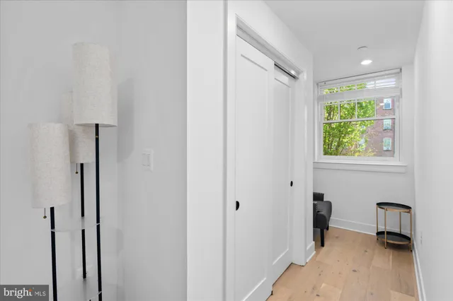 a view of a hallway with a window and a bathroom