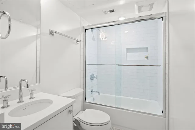 a bathroom with a bathtub shower sink vanity and toilet