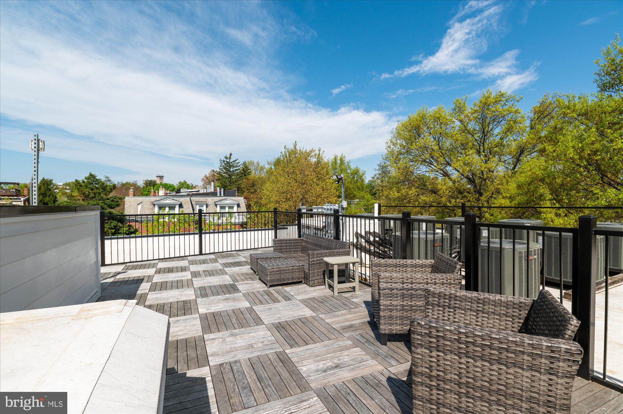 2869 28th Street Northwest, Unit 301 Washington, DC 20008 - Photo 29 of 31 a view of a patio with lawn chairs floor to ceiling window and city view
