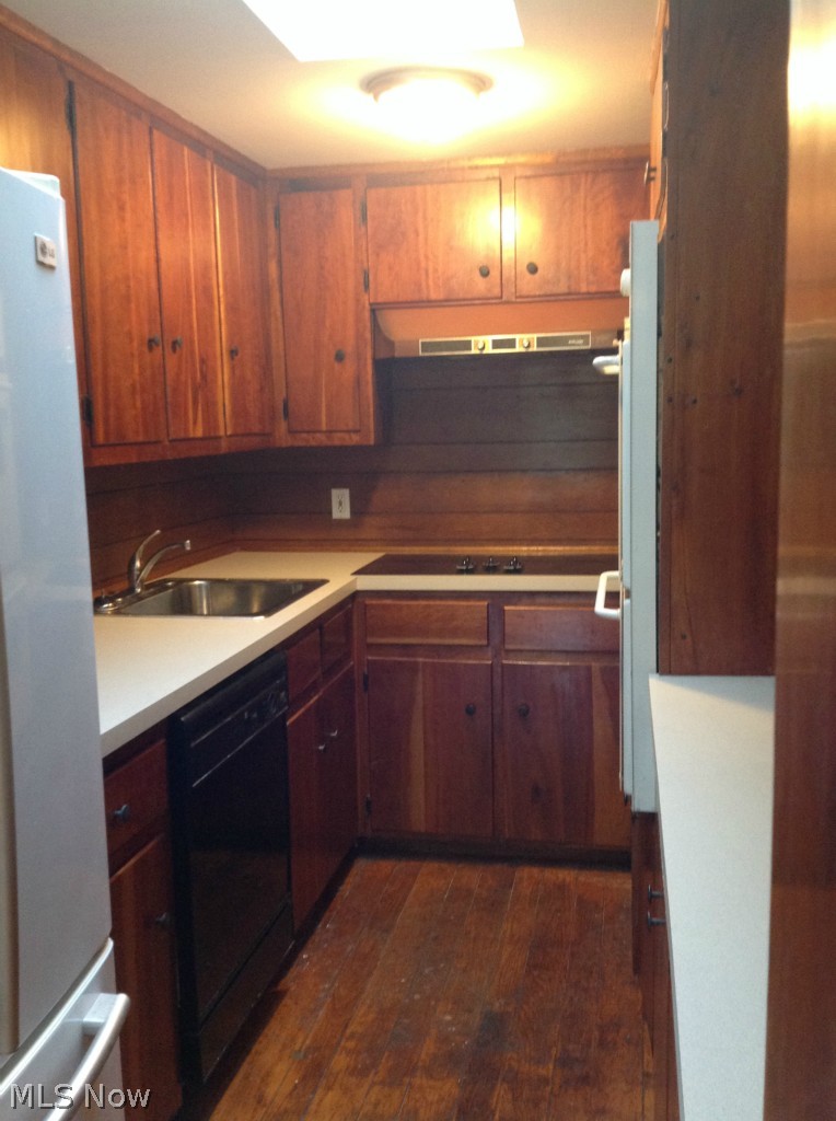 1764 Ridgewood Road Wadsworth, OH 44281 - Photo 6 of 24 Galley style kitchen with original cherry cabinetry, original wood flooring, new counter tops, modern conveniences of dishwasher, built in oven, and brick built in wood burner.