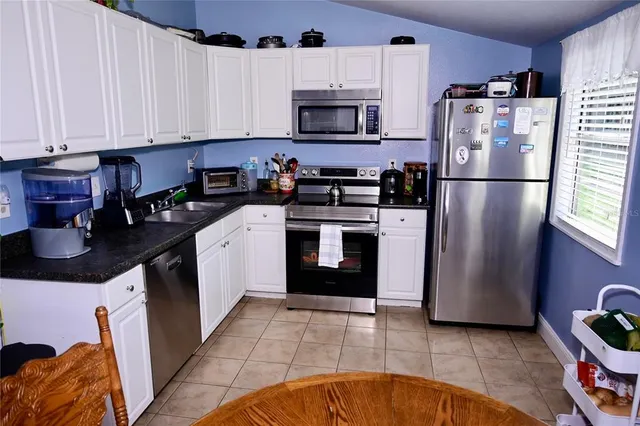 a kitchen with stainless steel appliances granite countertop a refrigerator stove and sink