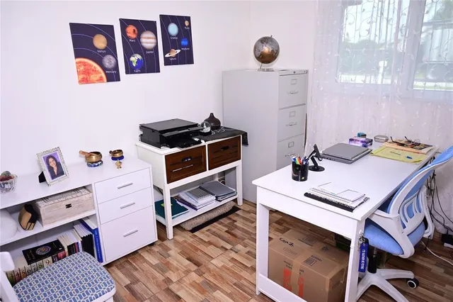 a washing machine sitting inside of a kitchen with stainless steel appliances wooden floor and cabinets