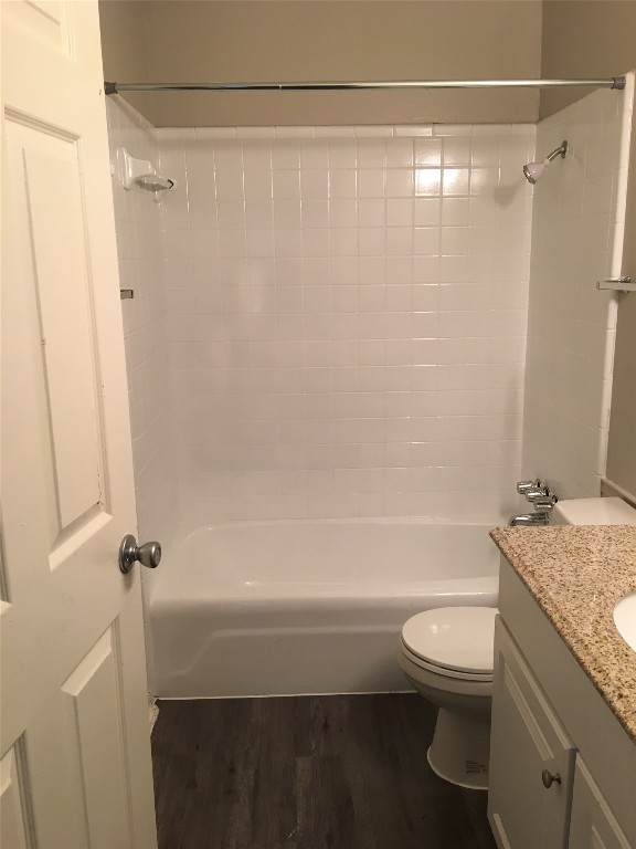 6504 South 1st Street, Unit 104 Austin, TX 78745 - Photo 3 of 5 a bathroom with a granite countertop bathtub shower sink vanity and toilet
