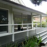a view of a house with a large window and wooden fence