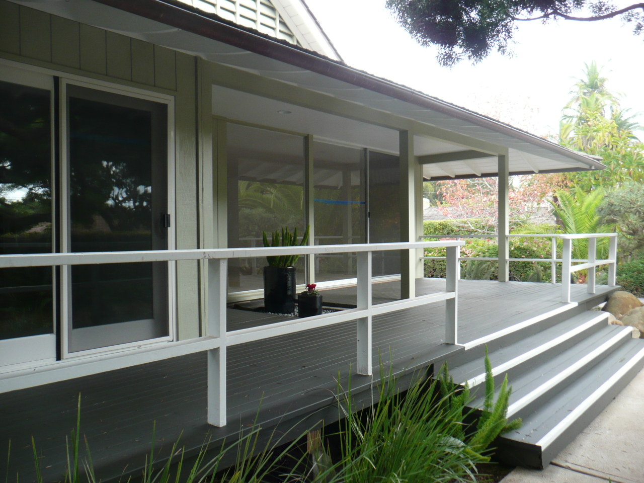a view of a house with a large window and wooden fence