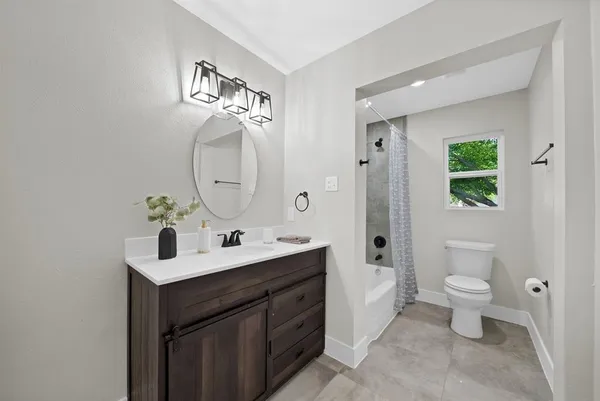 a bedroom with a bed a chandelier and a window