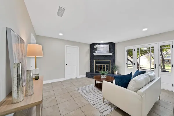 a living room with furniture fireplace and a large window