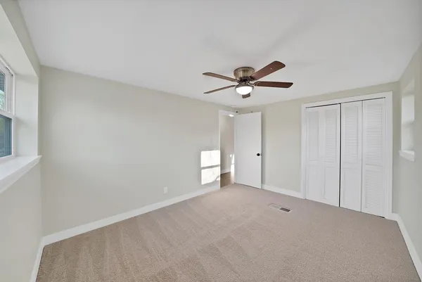 a view of a room with a ceiling fan and a window