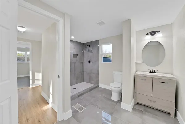 a view of a big room with wooden floor and windows