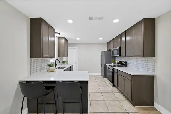 a kitchen with granite countertop a sink stainless steel appliances and cabinets