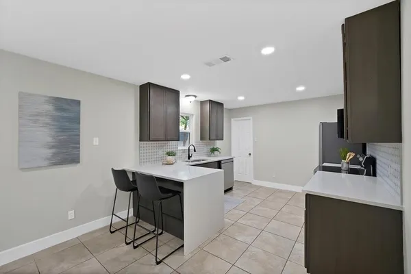 a kitchen with stainless steel appliances a sink stove and refrigerator