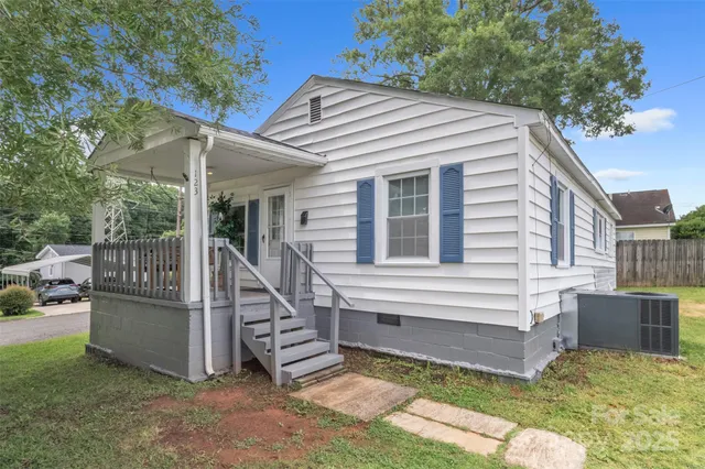 a view of house with a yard and sitting area