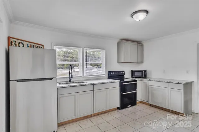 a kitchen with white cabinets and white appliances