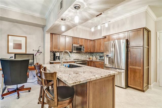 a kitchen with kitchen island a refrigerator stove microwave and cabinets