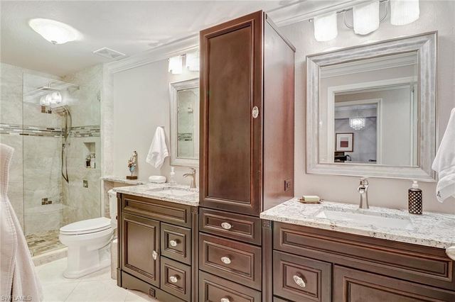 a bathroom with a granite countertop sink a toilet mirror and bathtub