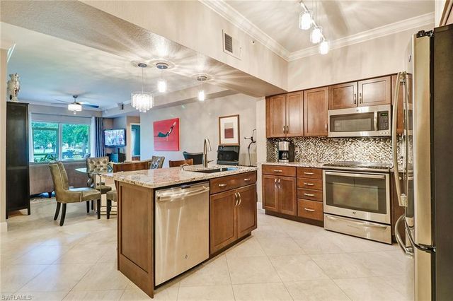 a kitchen with stainless steel appliances granite countertop a sink and cabinets