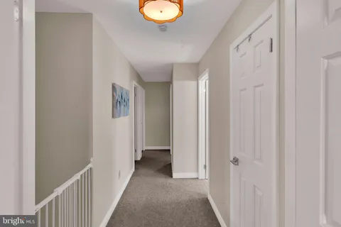a view of a hallway with wooden floor and entryway