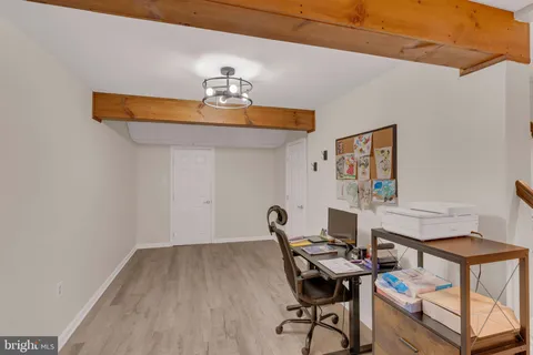 a view of a workspace with furniture and wooden floor
