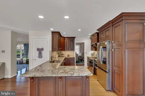 a kitchen with stainless steel appliances granite countertop a sink refrigerator and cabinets