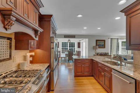 a kitchen with stainless steel appliances granite countertop a stove and a sink