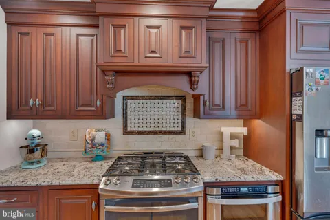 a kitchen with granite countertop a stove and cabinets