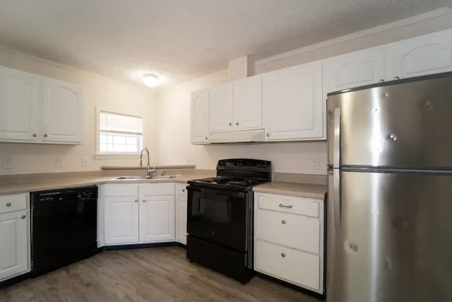 a kitchen with a refrigerator sink and cabinets