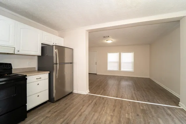 a kitchen with a refrigerator and a stove top oven