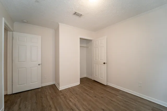 a view of an empty room with wooden floor