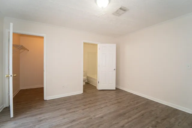 an empty room with wooden floor and closet