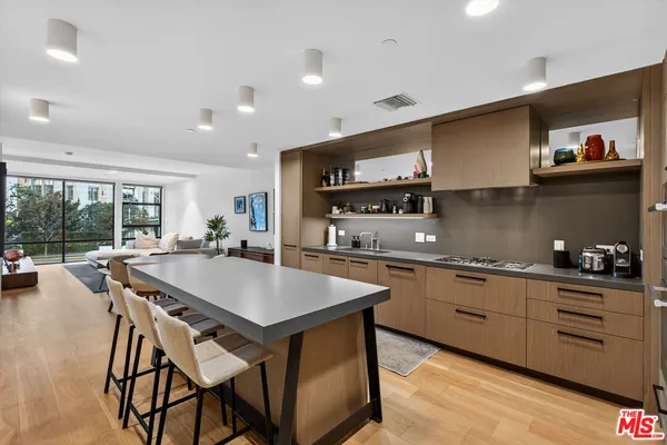 a kitchen with stainless steel appliances granite countertop a kitchen island a stove and a sink