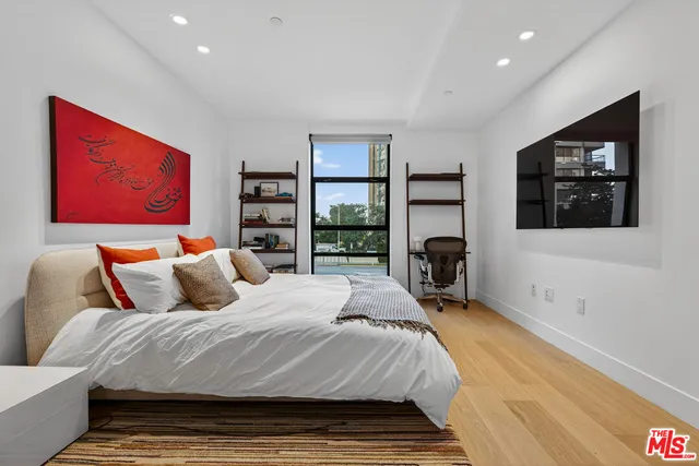 a bedroom with a bed and a large window