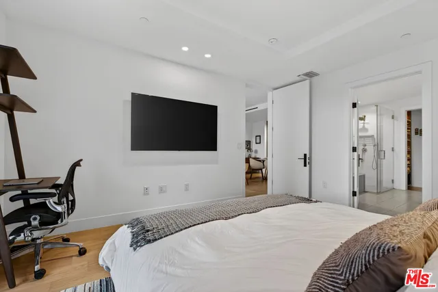 a bedroom with a bed and a flat screen tv