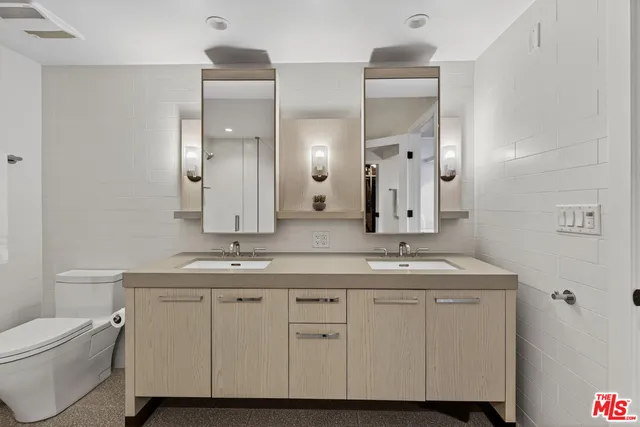 a bathroom with a granite countertop sink a toilet and a mirror
