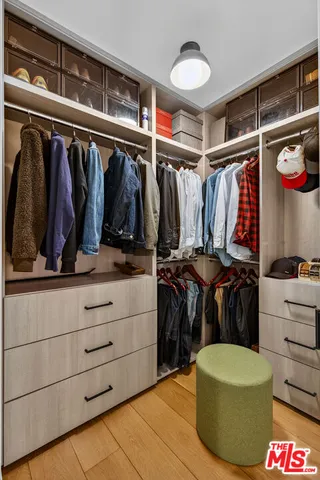 a view of walk in closet with clothes and shoes