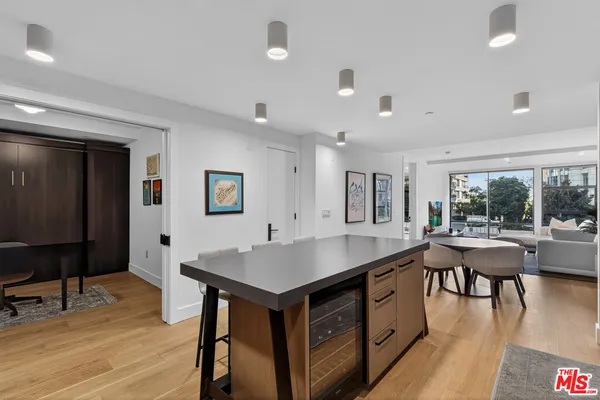 a kitchen with a table chairs and wooden floor