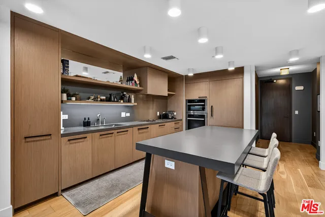 a kitchen with stainless steel appliances granite countertop a sink refrigerator and cabinets