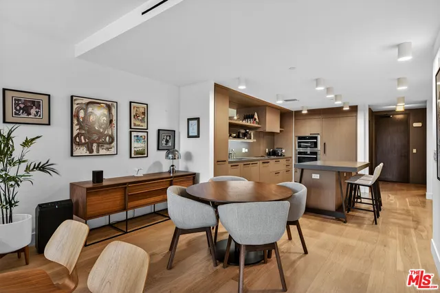 a living room with furniture a large window and wooden floor