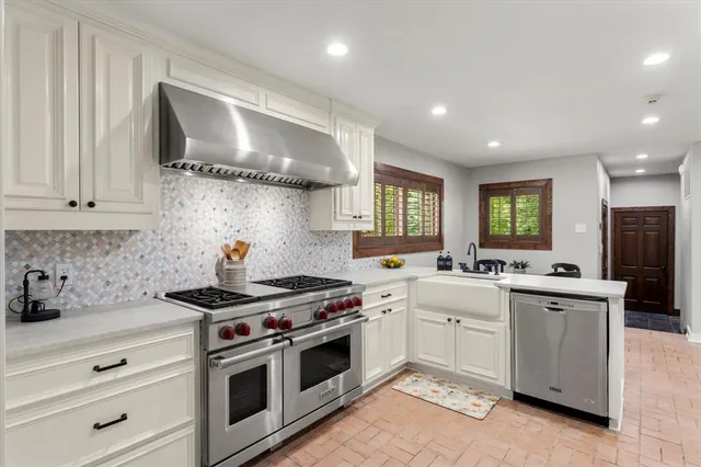 a kitchen with stainless steel appliances a sink stove and cabinets
