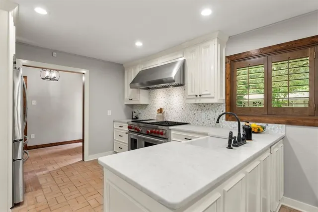 a kitchen with stainless steel appliances a sink stove and refrigerator