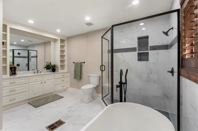 a bathroom with a sink a toilet and shower