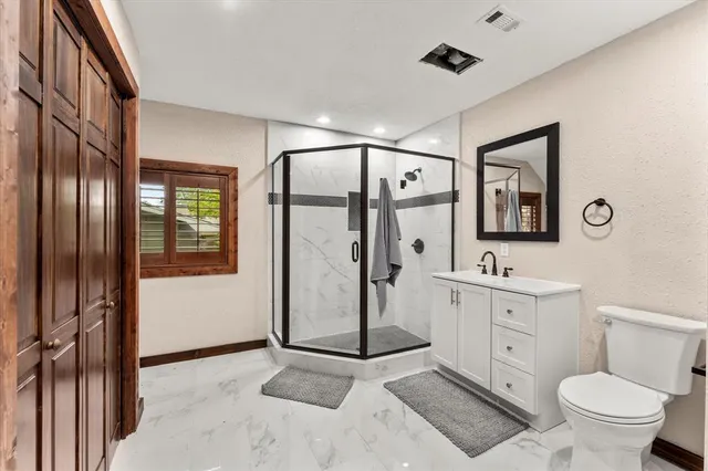 a spacious bathroom with a toilet a sink and mirror