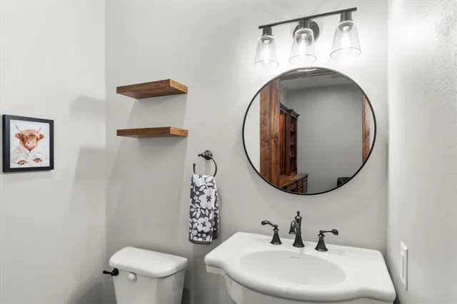 a bathroom with a toilet sink and mirror