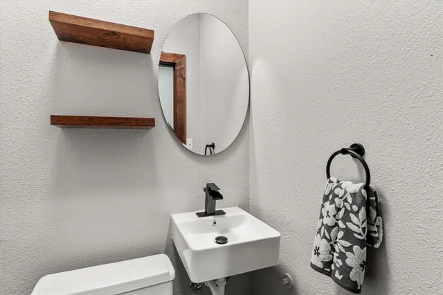 a bathroom with a sink a toilet and a mirror
