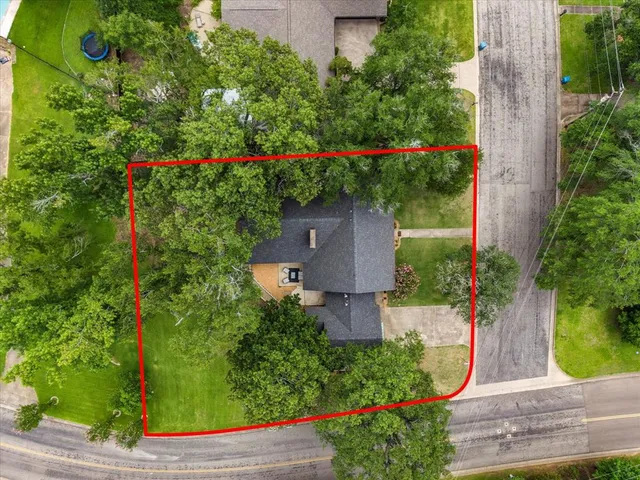 an aerial view of residential houses with outdoor space and trees