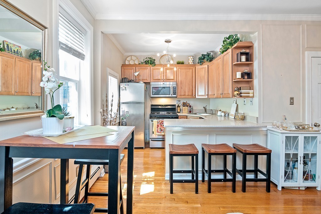8 Lindall Place, Unit 2 Boston, MA 02114 - Photo 4 of 21 a kitchen with stainless steel appliances granite countertop a table and chairs in it