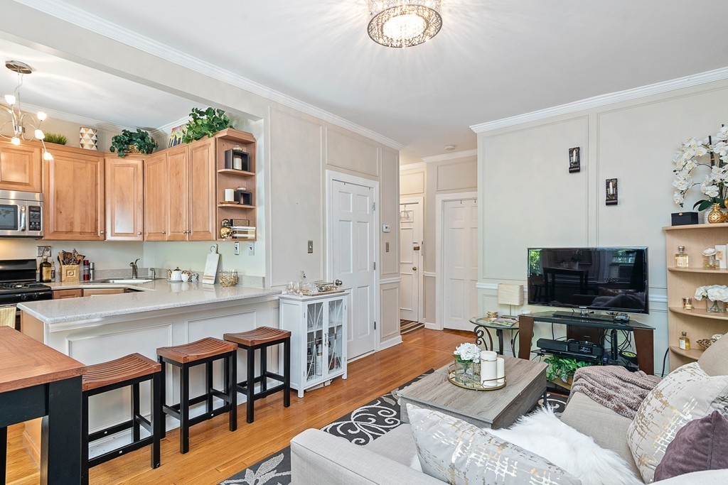 8 Lindall Place, Unit 2 Boston, MA 02114 - Photo 5 of 21 a living room with furniture a flat screen tv and kitchen view