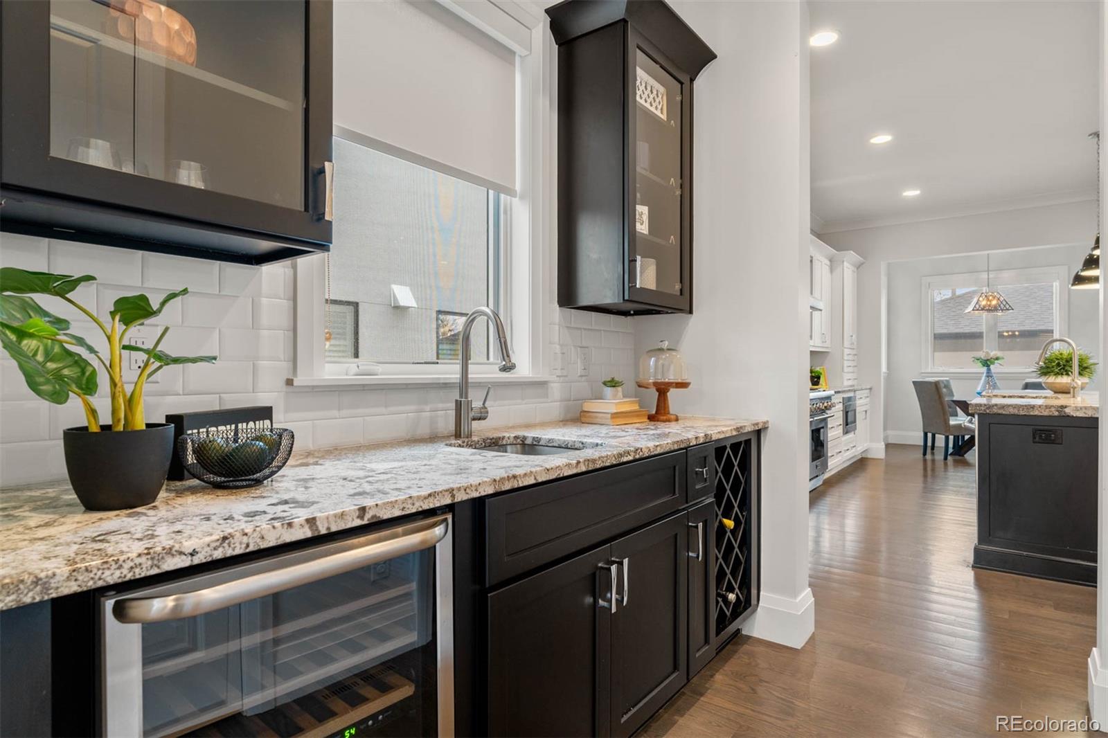 1645 South Cook Street Denver, CO 80210 - Photo 19 of 48 a kitchen with stainless steel appliances granite countertop a sink a stove and a wooden floors